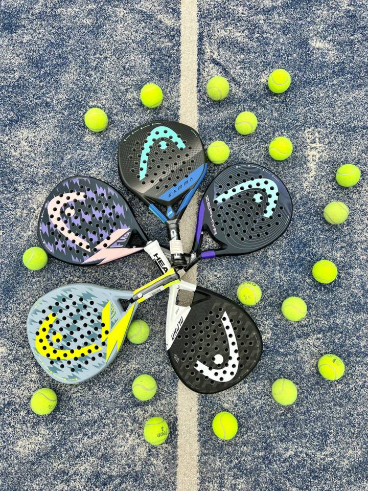 Fem padelbat samlet på en bane omgivet af gule bolde